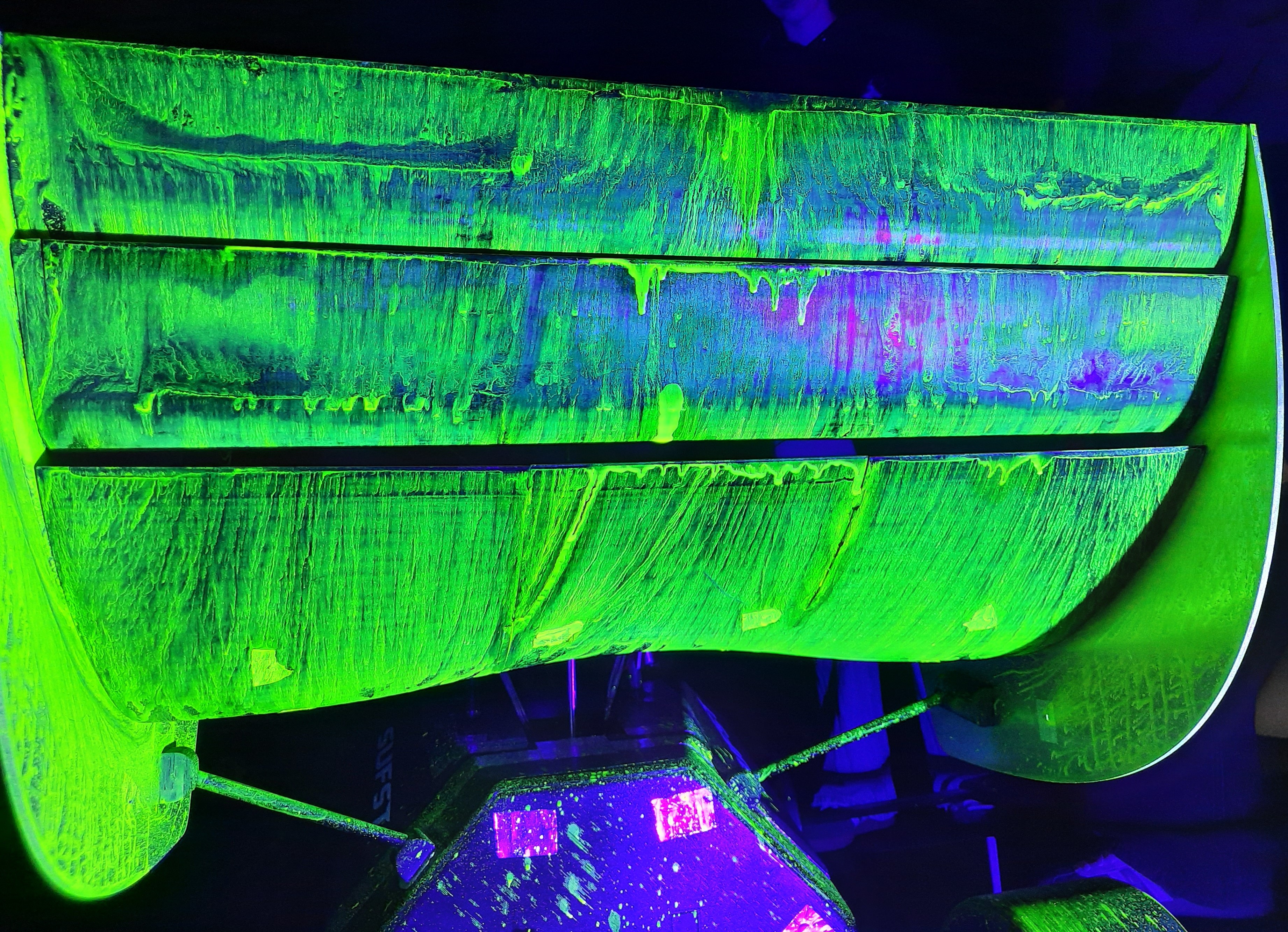 Wind tunnel flow-vis paint on the rear wing under UV light